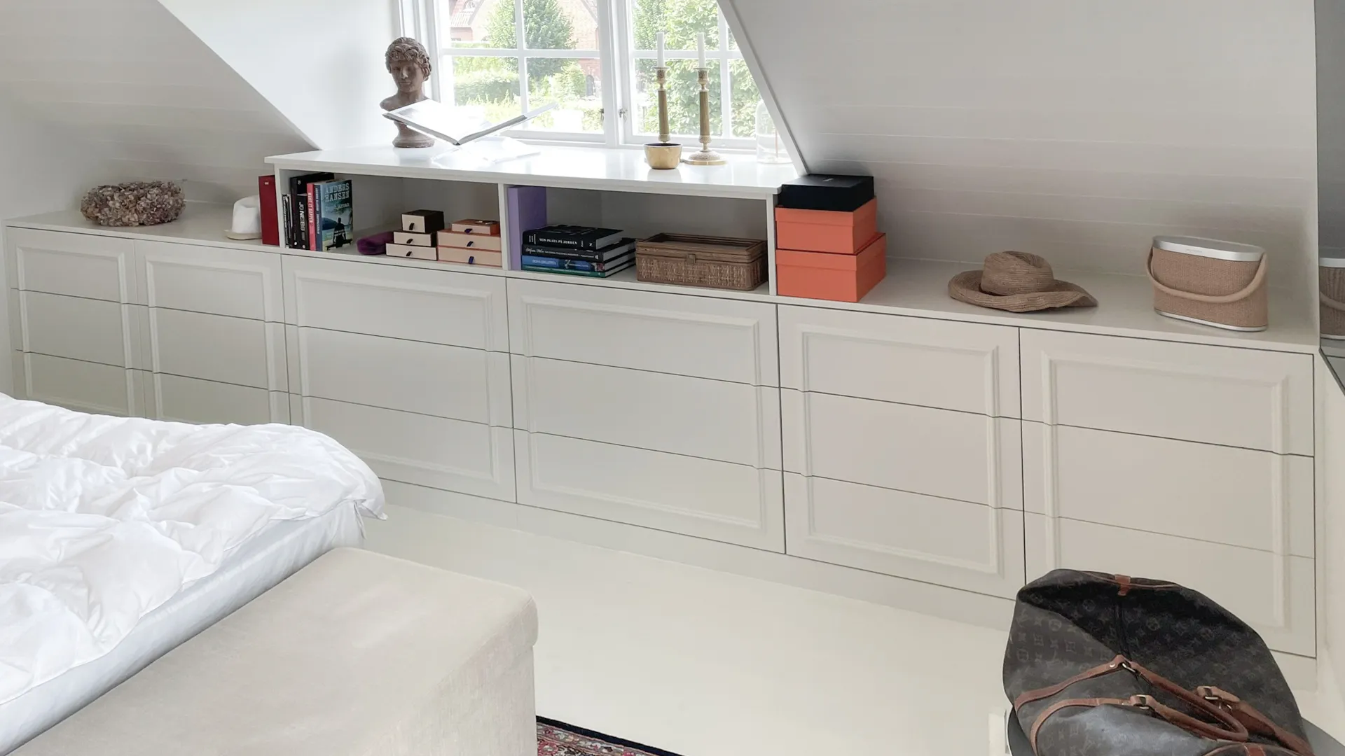 Fitted bedroom storage in Malmö built into a sloped attic ceiling